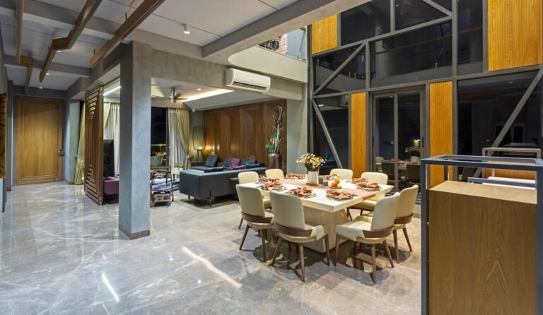 Modern dining and living room with large windows and elegant furniture.