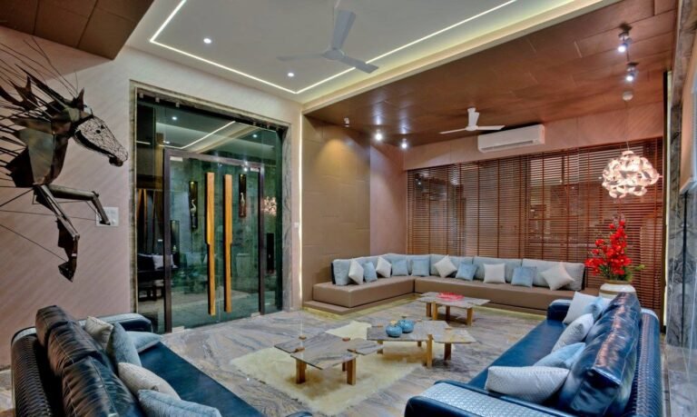 Modern living room with sectional sofa, artistic light fixtures, and abstract horse sculpture.