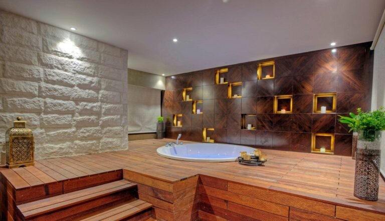 Luxurious bathroom with wood floors, built-in tub, and illuminated wall shelves.