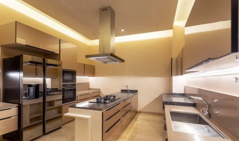 Modern kitchen interior with ambient lighting, stainless steel appliances, and granite countertops.