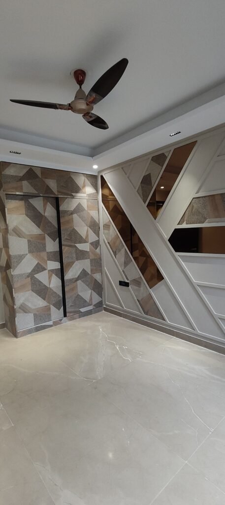 Modern interior featuring geometric wall designs, a ceiling fan, and polished marble floors, creating a stylish and airy atmosphere.