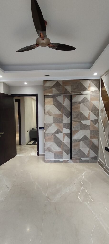 Modern interior featuring geometric wall designs, a ceiling fan, and polished marble floors, creating a stylish and airy atmosphere.