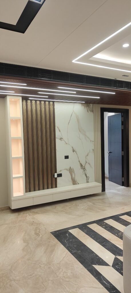 A modern dining area with a rectangular table, six chairs, marble floors, and a decorative partition featuring a leaf pattern. The space has recessed lighting and neutral tones.