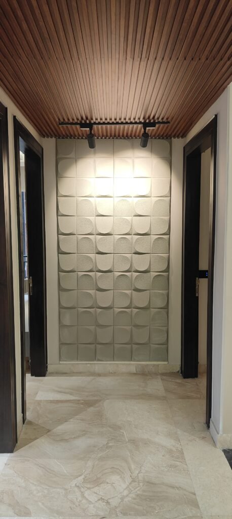A hallway features a textured accent wall with geometric patterns, a wooden slatted ceiling, marble flooring, and doorways on both sides.